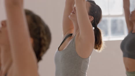 yoga class healthy caucasian woman practicing warrior pose enjoying fitness lifestyle exercising with multi ethnic people in workout studio