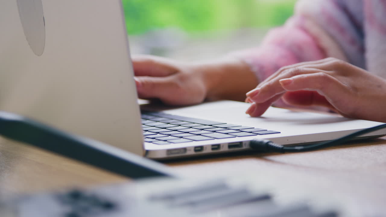 Close Up Of Female Vlogger Typing On Laptop With Headphones And Microphone In Foreground