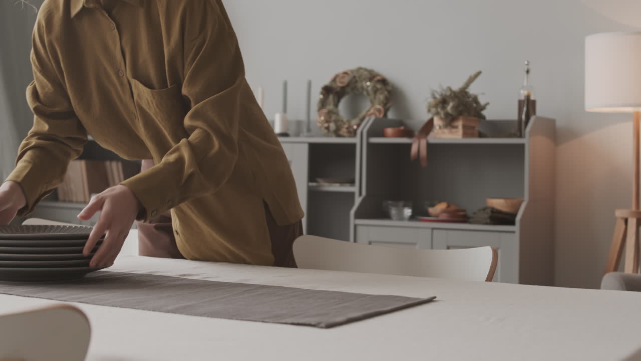 человек, устраивающий тарелки на столе