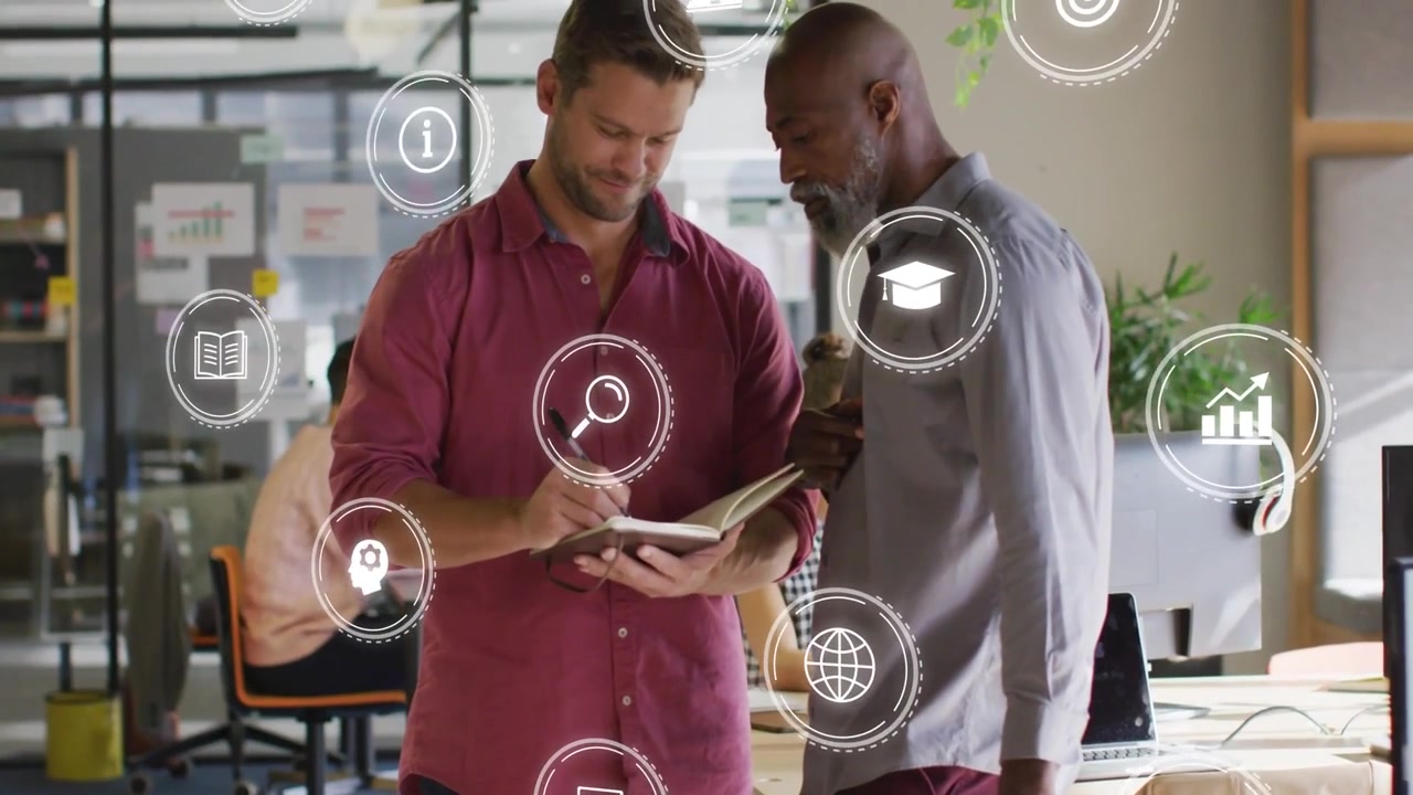 Vertical video: Two men reviewing plan in office, writing while leaning, note sparking tech icons