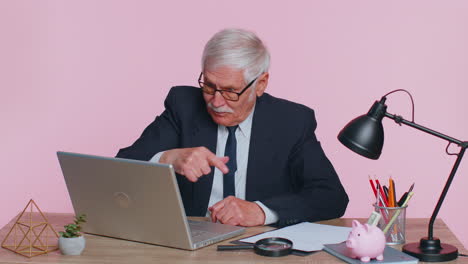 Senior-office-businessman-looking-at-camera-doing-phone-gesture-like-says-hey-call-me-back-contact