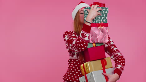 Girl-in-Christmas-red-sweater,-Santa-hat-smiling,-holding-many-gift-boxes-New-Year-presents-shopping