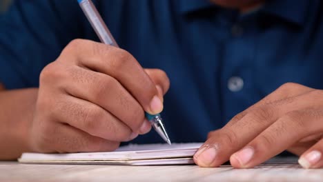 persona que escribe en un cuaderno