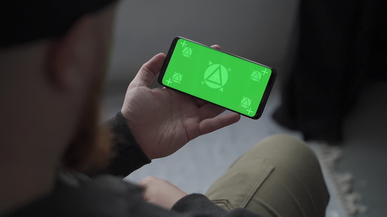 수평 녹색 화면 크로마를 가진 스마트폰을 들고 있는 남자, 읽고, 만지고. 모형.