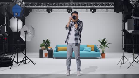 full body of asian photographer using a camera taking picture while standing in the studio