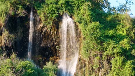 La-Cascada-Natural-Que-Fluye-Por-La-Montaña-Está-Iluminada-Por-El-Sol-Vespertino