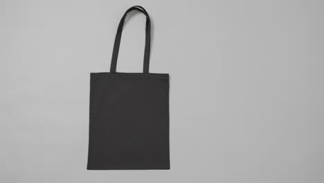 close up of black bag on grey background, with copy space, slow motion