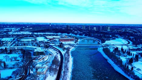 aerial winter panoramic flyover the north saskatchewan river from north to south in between the alberta treasury board and finance, the walter dale iconic white bridge, kinsmen park, 109 st nw 3-3