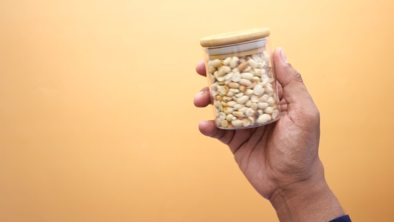 con un recipiente de maní ,