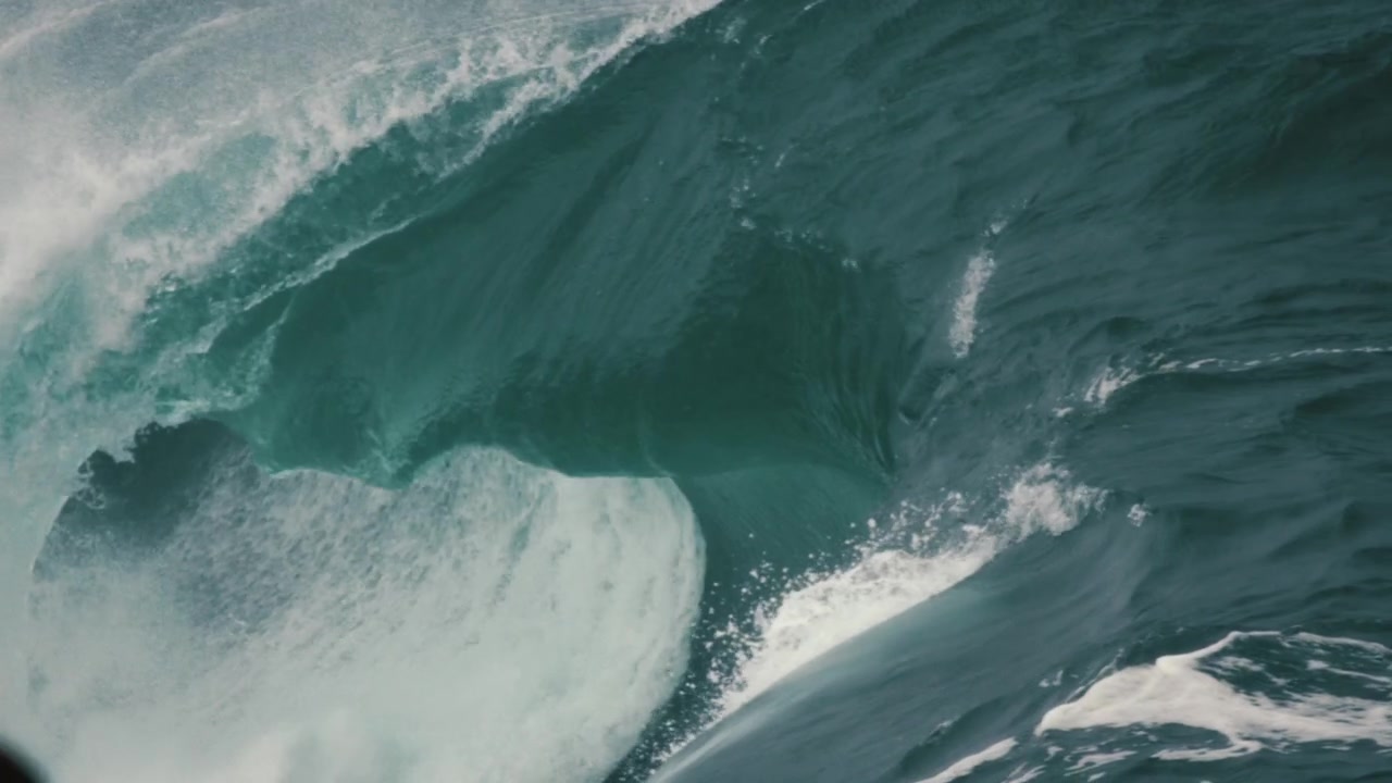 Close up of large, heavy waves breaking onto rocks. Playing in glass like slow motion.