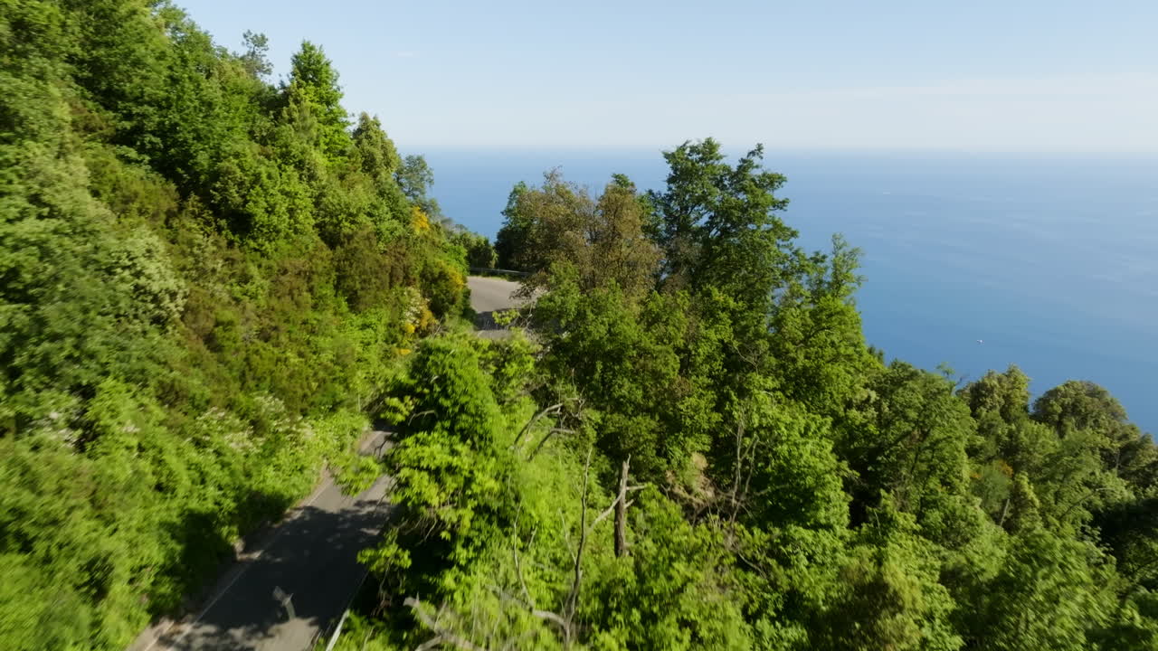 Vista aerea che segue un camper che guida su una strada ad alta quota in Liguria, Italia