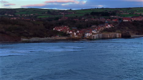 establishing drone shot towards robin hoods bay on winter morning uk