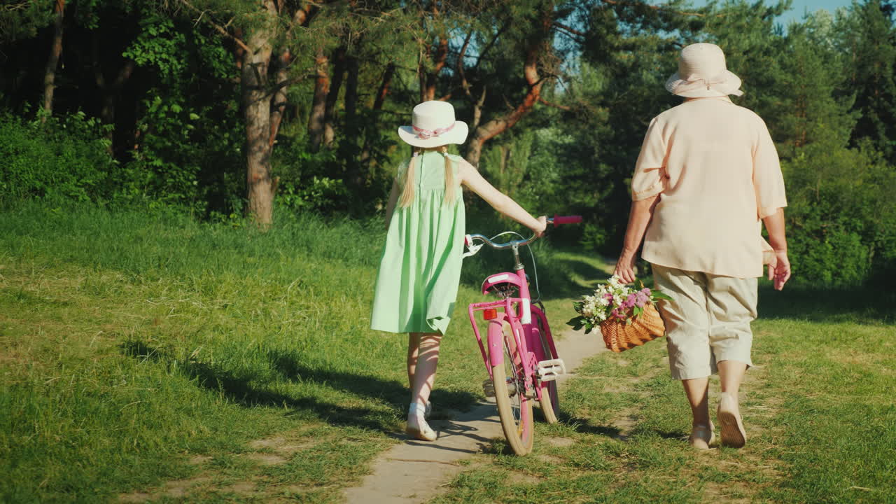 бабушка гуляет с внучкой девочка едет на велосипеде бабушка несет корзину