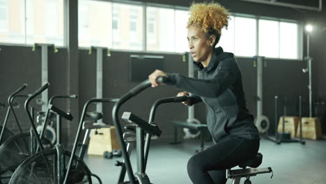 woman exercising on an air bike in the gym