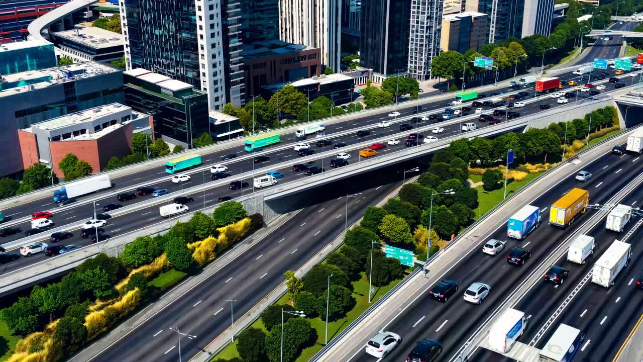 Aerial video shot of a bustling highway surrounded by skyscrapers, showcasing urban life and traffic