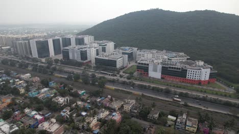 Aerial-Drone-Shot-Of-Buildings-Near-A-Hugh-Hill-Near-A-Highway-Traffic