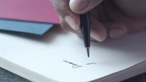 person writing notes in a notebook