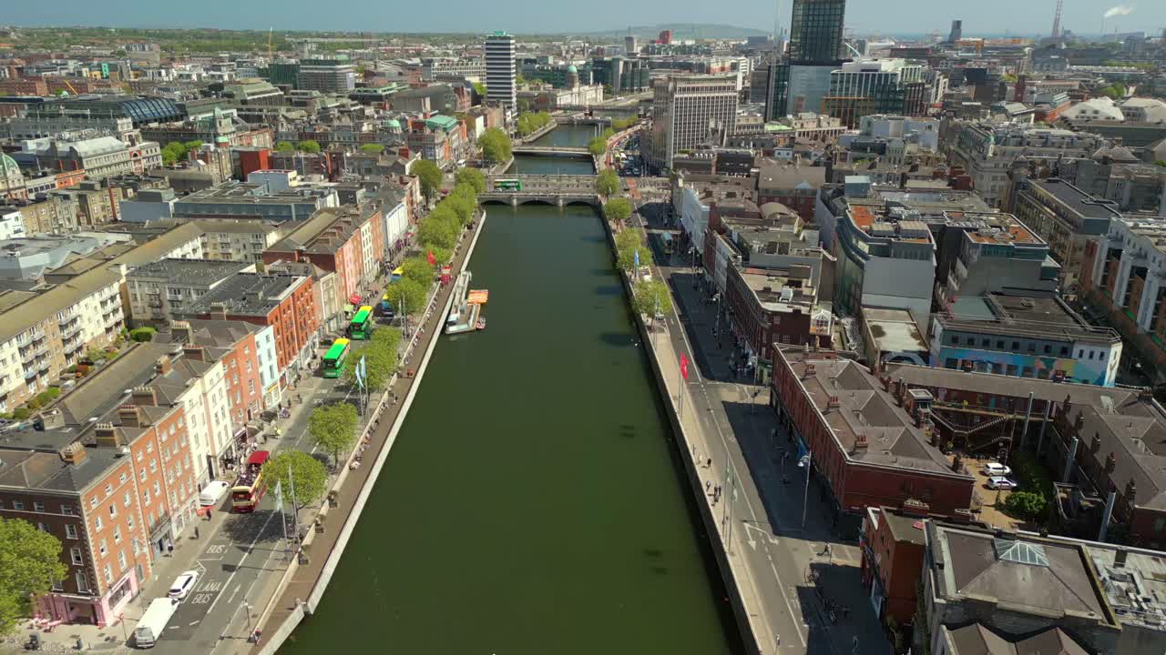 Centre-on, reversing aerial video of the River Liffey, various bridges and Dublin City Centre in Dublin, Ireland on a bright and sunny day. Filmed in 4K, 60FPS and with Rec709 color.