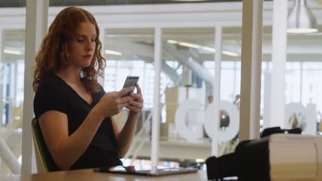 mujer de negocios usando teléfono móvil en la oficina 4k