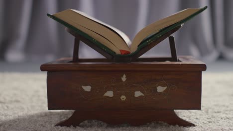 close up of open copy of the quran on stand at home 6