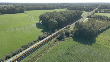 aerial of train driving through beautiful dutch countryside