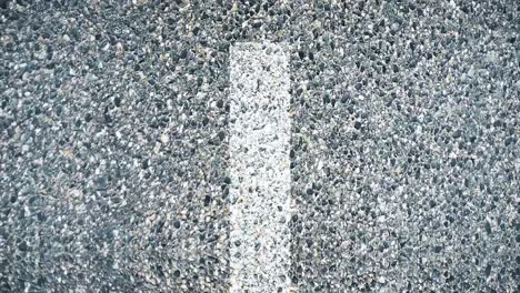 close up of a gray asphalt road with white line