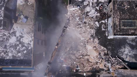 fotografía de la parte superior de una excavadora limpiando los escombros de los edificios derrumbados en la calle david bloch, tel aviv, israel