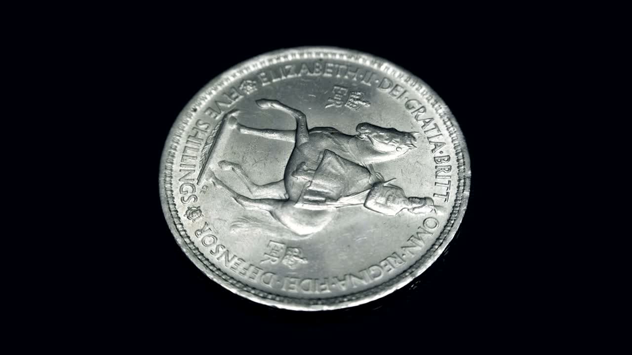 English coin five shillings rotates on a black background. Macro. Closeup
