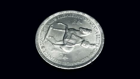 english coin five shillings rotates on a black background. macro. closeup
