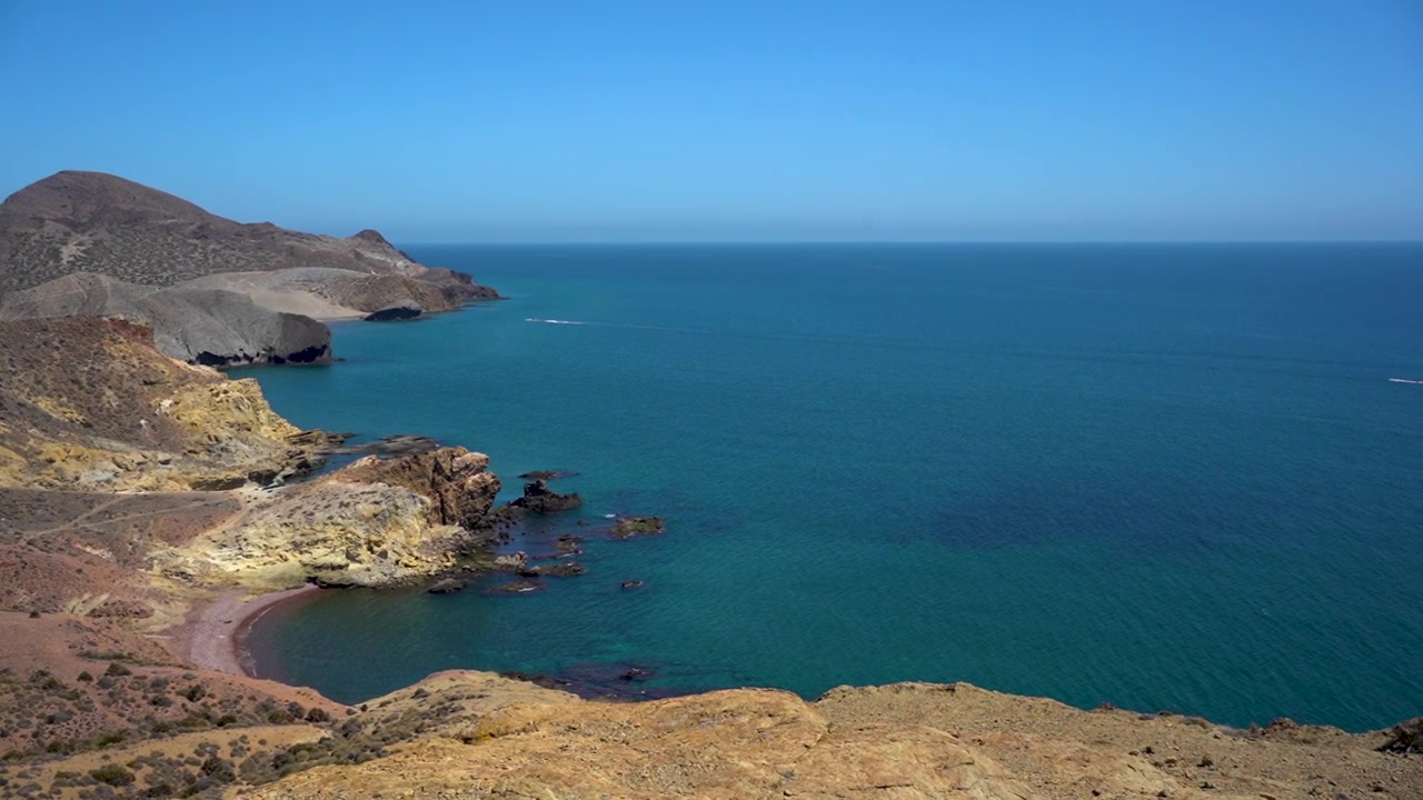 Paesaggio costiero con scogliere e oceano sotto un cielo blu, evoca tranquillità