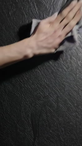 cleaning a dark surface with a cloth