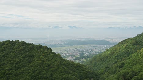 kathmandu valley and himalayas mountains scenery, forest landscape in the foothills and kathmandu cityscape with the city behind