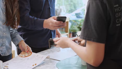 closeup manos de cliente hombre y mujer comprando café y pagando juntos con billetera digital para la banca a barista en el café, escanear pago con tecnología de código qr, pequeña empresa, negocio de puesta en marcha.