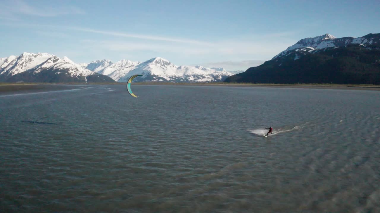Drone footage of a water skier para-skiing with a parachute on a windy summer day in Turnagain Arm of the Cook Inlet in Alaska