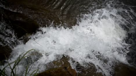 huge bolders are at the bottom of the falls, silky water flowing through the rocks, a beautiful landscape with a waterfall on a small mountain river