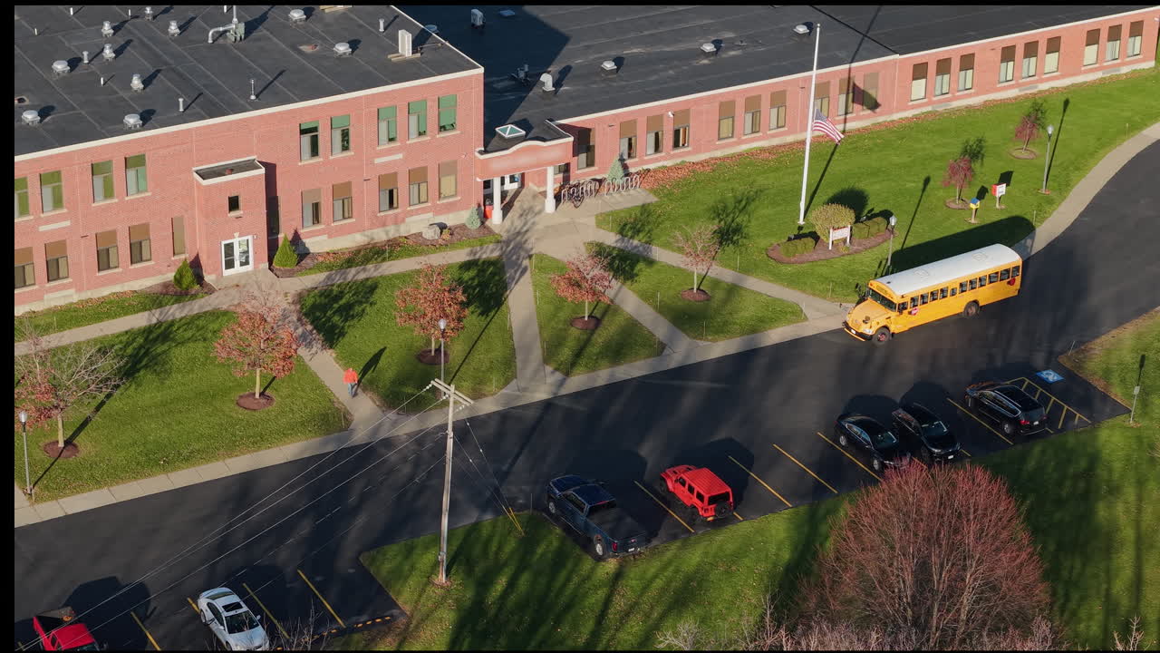 Aerial view of a school with a school bus and parking lot