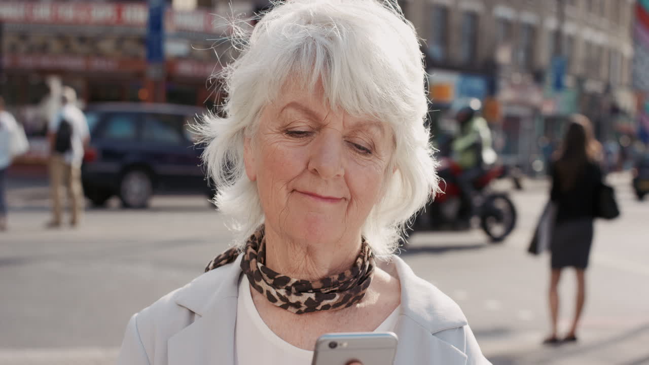 Ritratto al rallentatore di una donna anziana felice che usa lo smartphone
