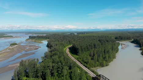 4k drone video of alaska railroad train trestle with mt