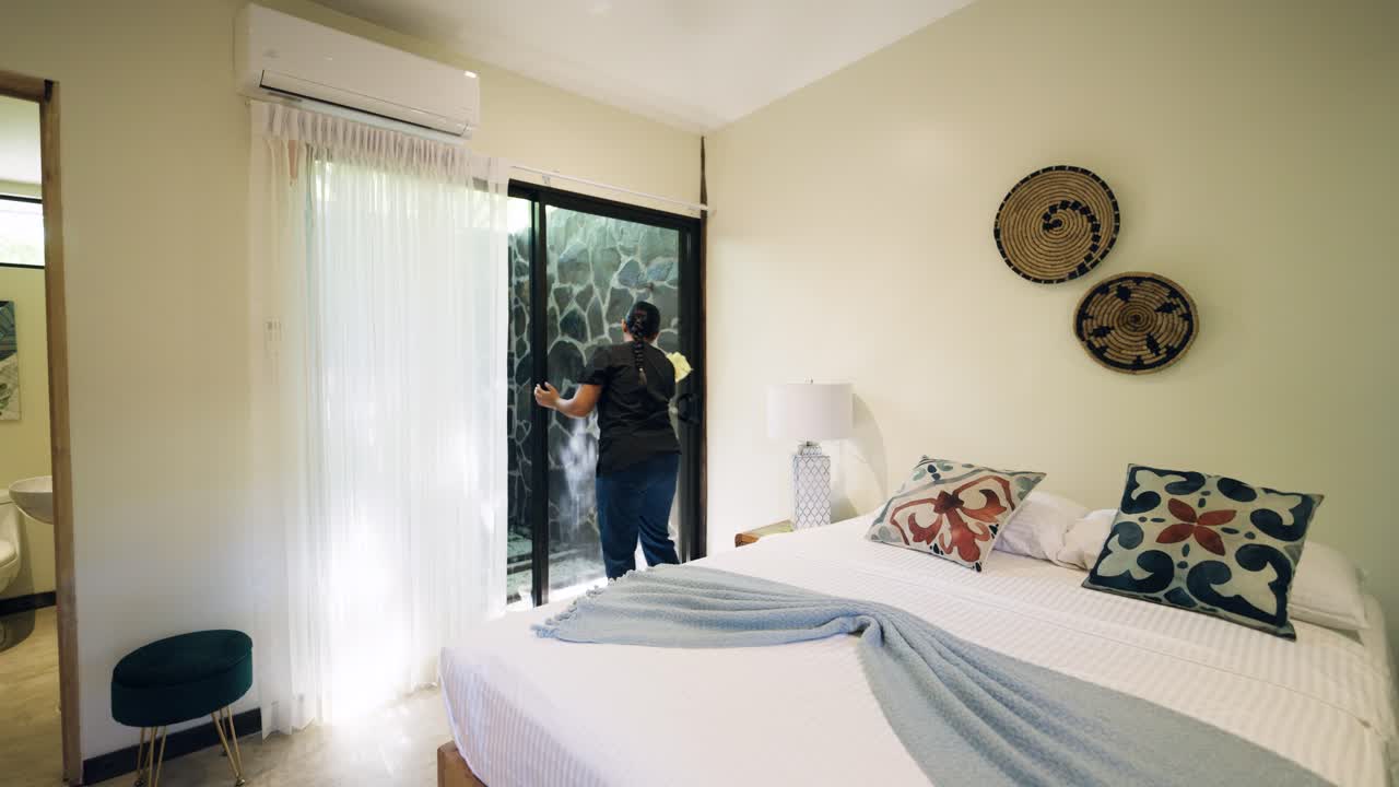 A person cleaning a window in a bedroom