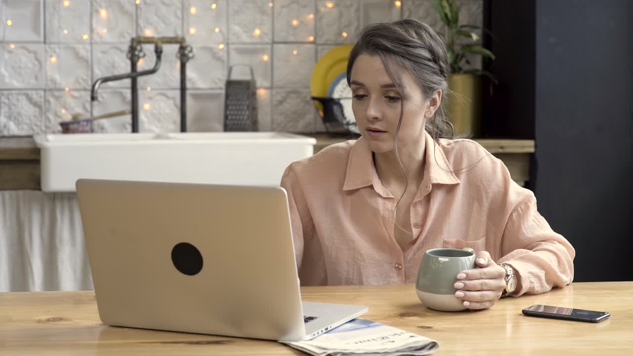 Woman working on laptop in a kitchen