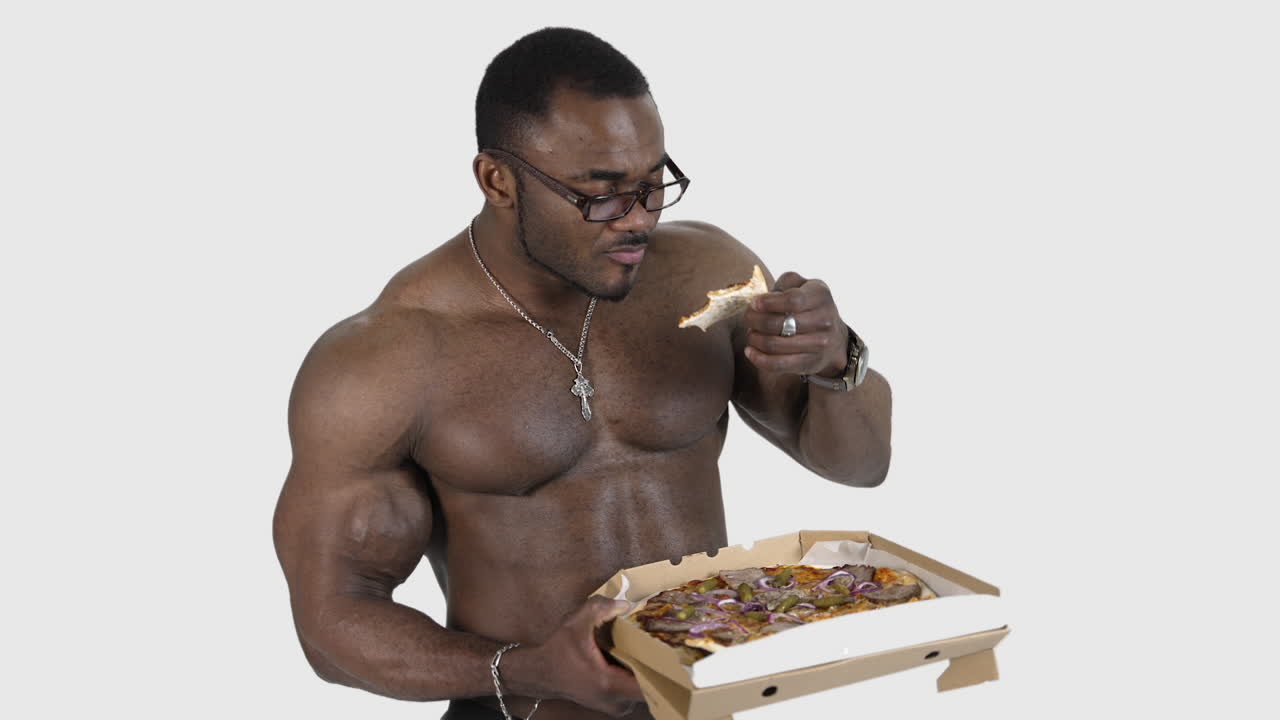 African male eating pizza. Fit young african man with beautiful torso eating pizza