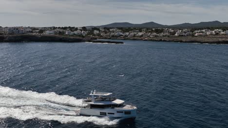 Toma-De-Drone-De-Un-Barco-Conduciendo-Junto-A-La-Ciudad-Portuaria-Española-En-Cámara-Lenta-Filmada-Por-Drone