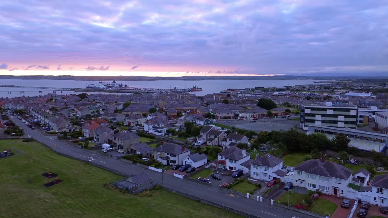 Early morning aerial view circling above Holyhead coastal suburban town sunrise during blue hour