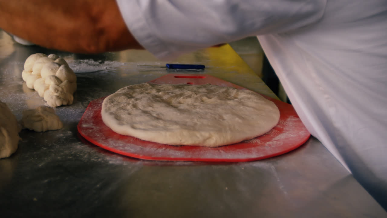 chef rociando la masa en la masa de la pizza 4k