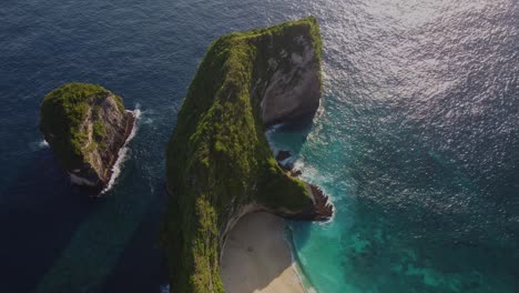 iconic aerial top-down view of kelingking beach, nusa penida, indonesia. dramatic cliffs, turquoise water, and a pristine hidden beach. stunning tropical landscape from above. shot in 4k.