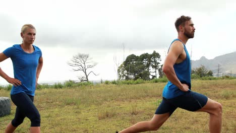 hombre y mujer en forma haciendo ejercicio durante una carrera de obstáculos