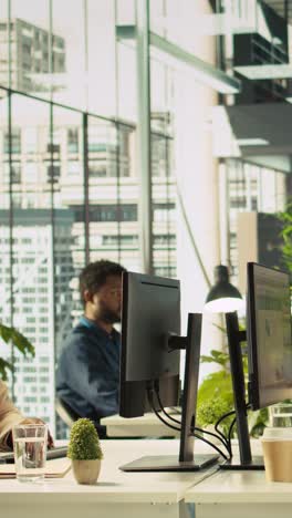 vertical video accountant in busy modern startup agency imputing financial figures on pc