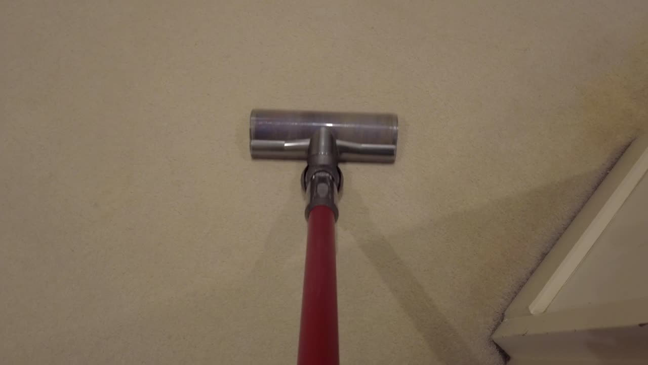 aspiradora de mano moviéndose hacia adelante y hacia atrás sobre una alfombra