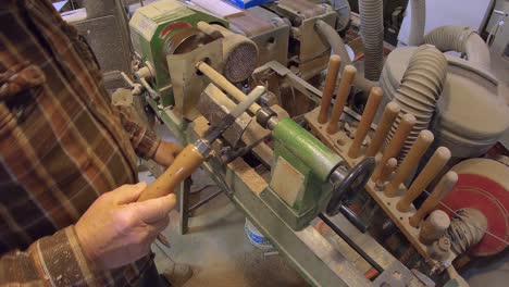 making wooden dowel rod on turning wooden lathe with chisel