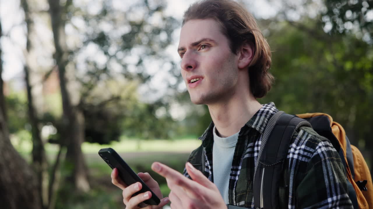Man with Backpack Using Phone Outdoors